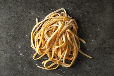 Uncooked homemade pasta on dark grey table, top view