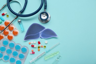 Photo of Paper liver and medical supplies on turquoise background, flat lay with space for text. Hepatitis treatment
