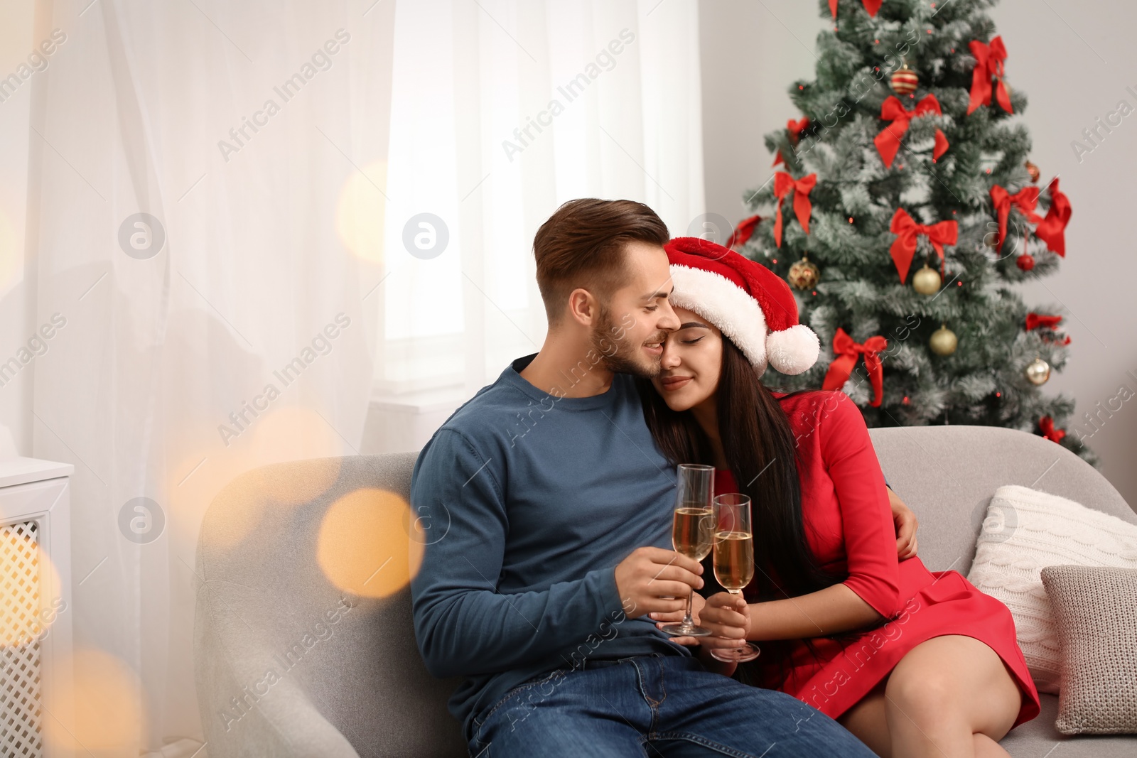 Photo of Young couple with glasses of champagne at home. Christmas celebration