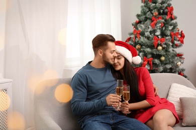 Young couple with glasses of champagne at home. Christmas celebration