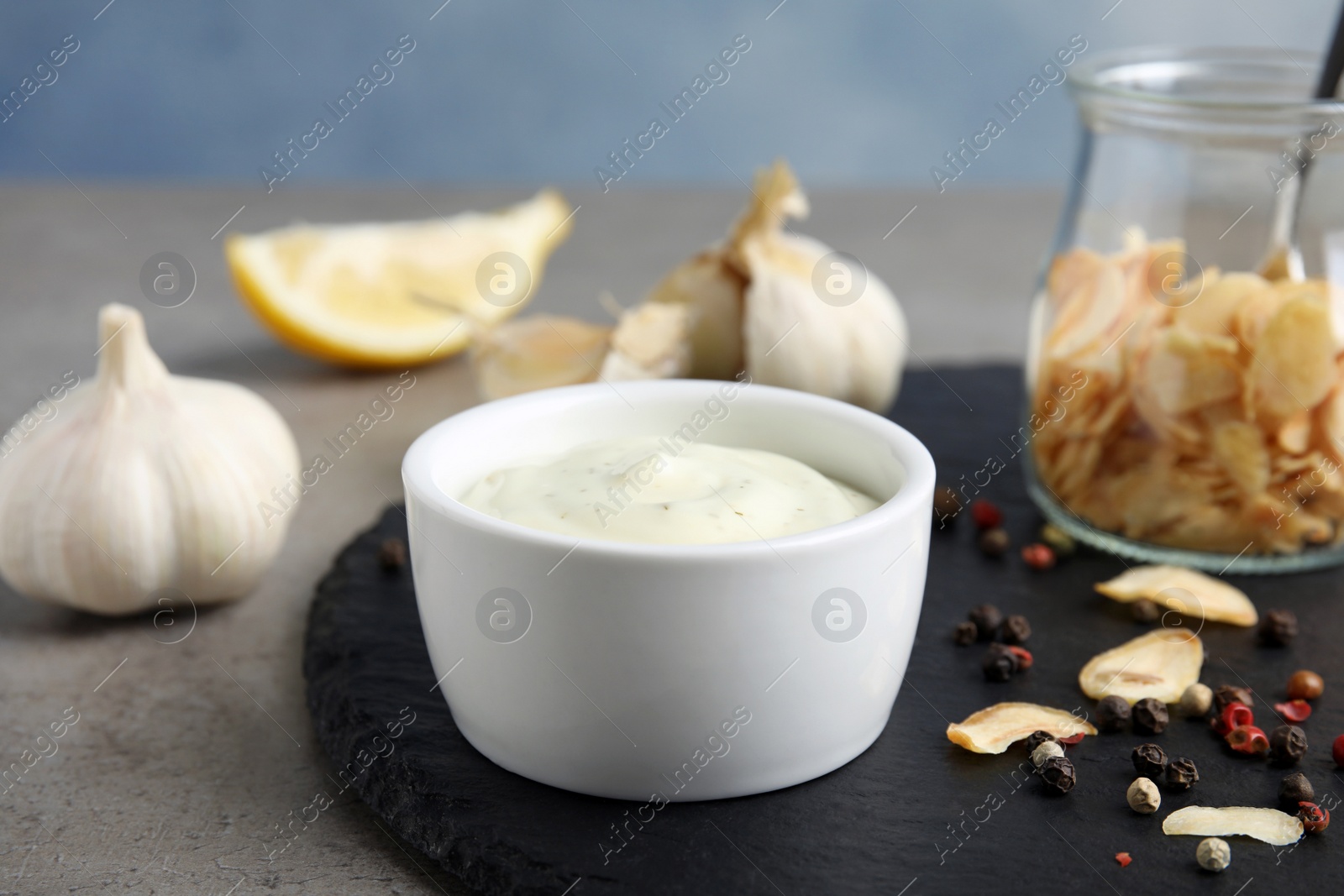 Photo of Composition with garlic sauce on grey table