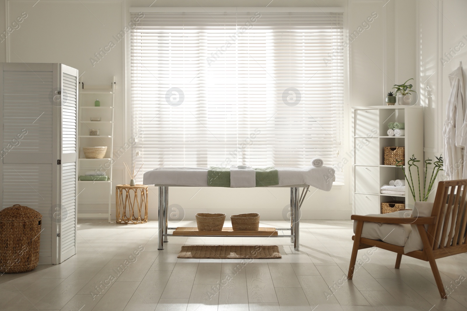 Photo of Stylish spa salon interior with massage table