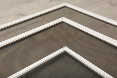 Photo of Set of window screens on wooden floor, closeup