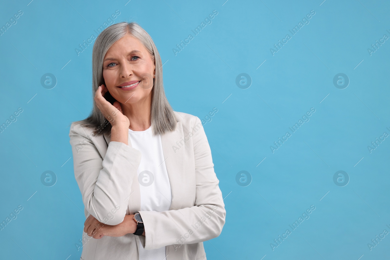 Photo of Portrait of beautiful middle aged woman on light blue background, space for text