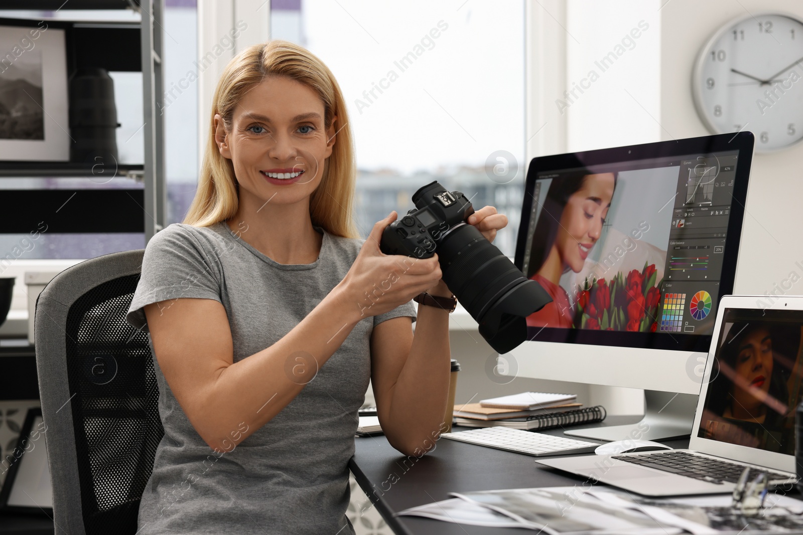 Photo of Professional photographer with digital camera at table in office