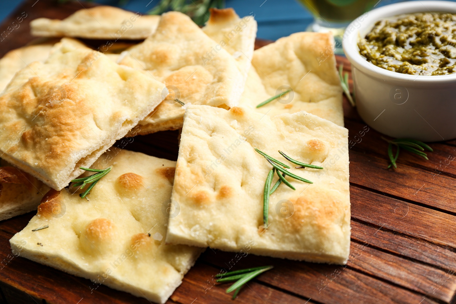 Photo of Delicious focaccia bread on wooden board, closeup