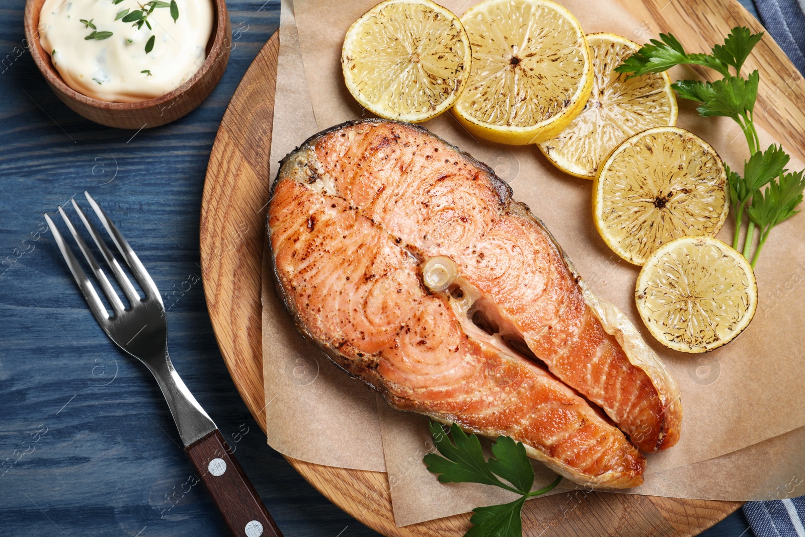 Photo of Flat lay composition with cooked red fish on blue wooden table