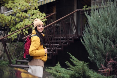 Photo of Female tourist with travel backpack on city street. Urban trip