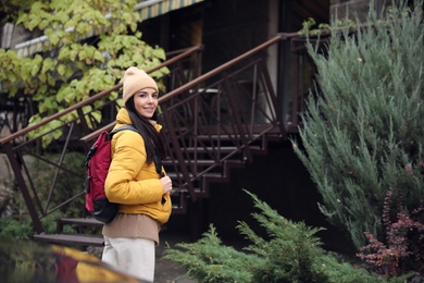 Female tourist with travel backpack on city street. Urban trip