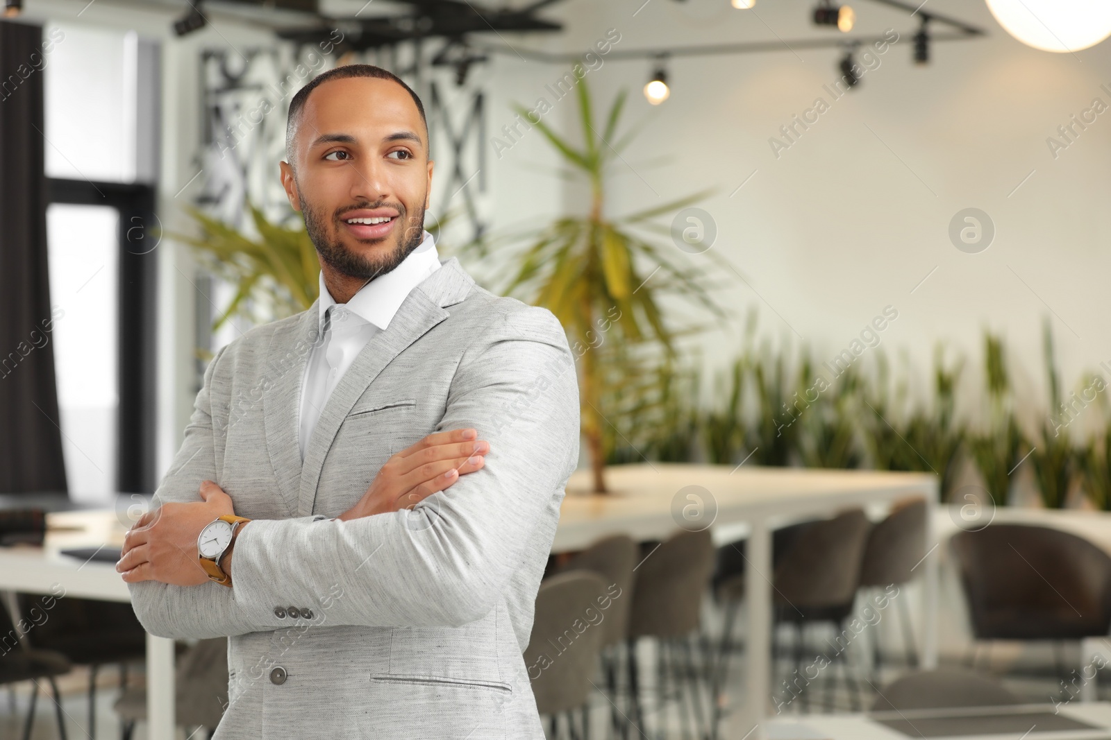 Photo of Happy man with crossed arms in office, space for text. Lawyer, businessman, accountant or manager