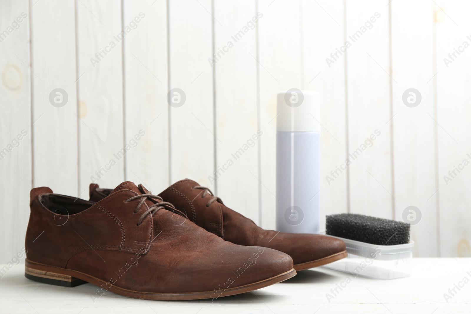 Photo of Stylish footwear with shoe care accessories on white  table