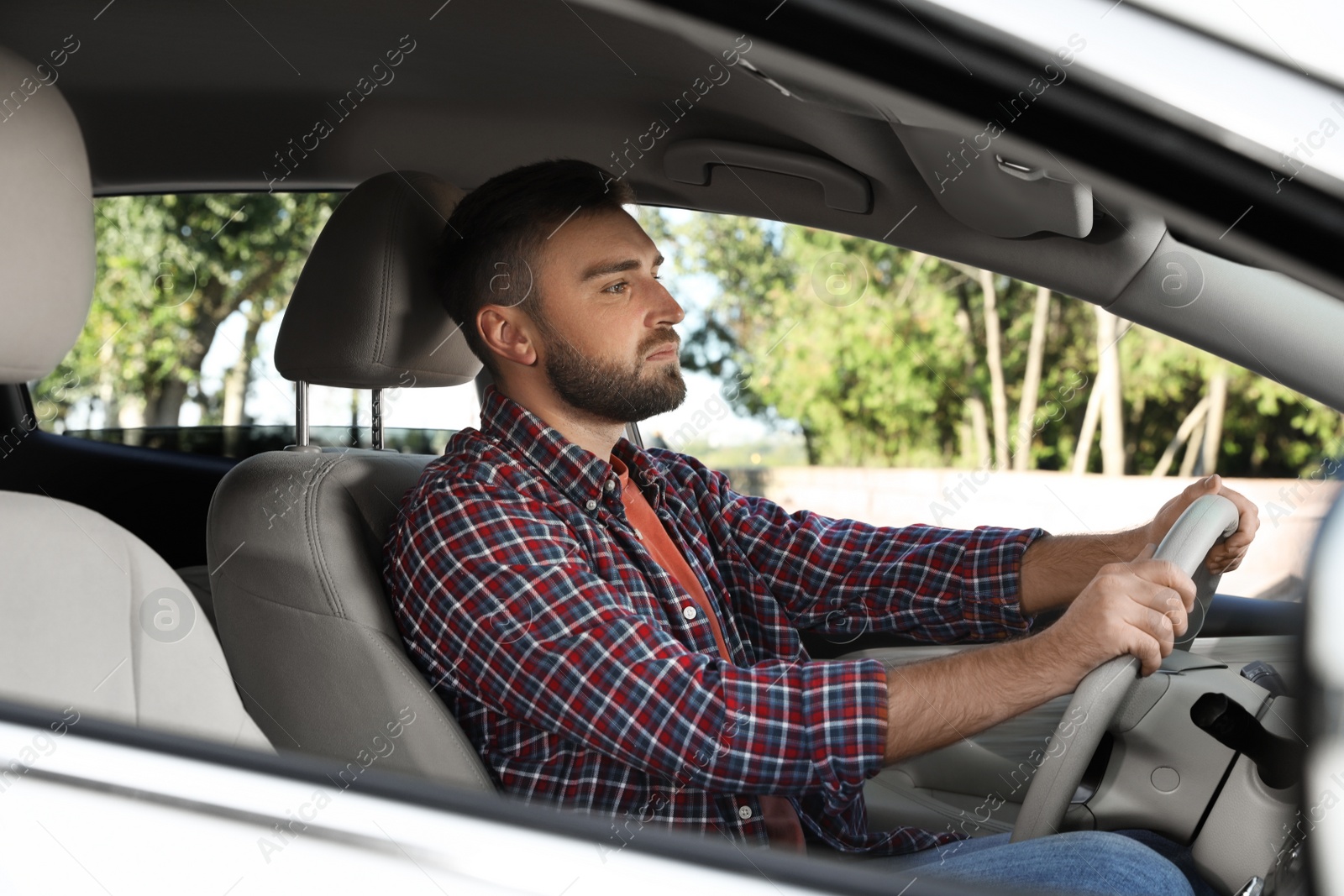 Photo of Handsome young driver sitting in modern car