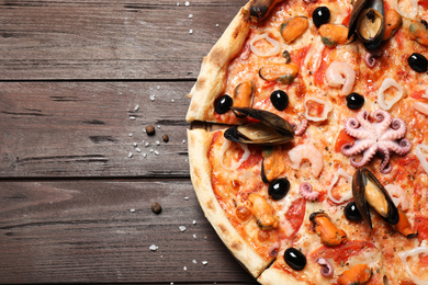 Tasty pizza with seafood on wooden table, top view. Space for text