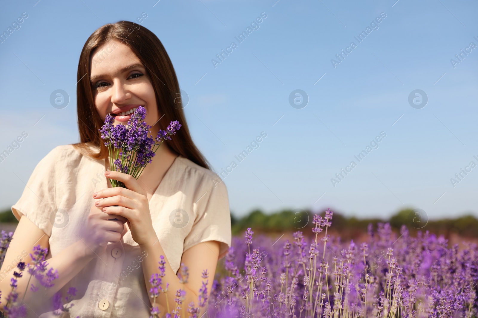 Photo of Young woman with lavender bouquet in field on summer day