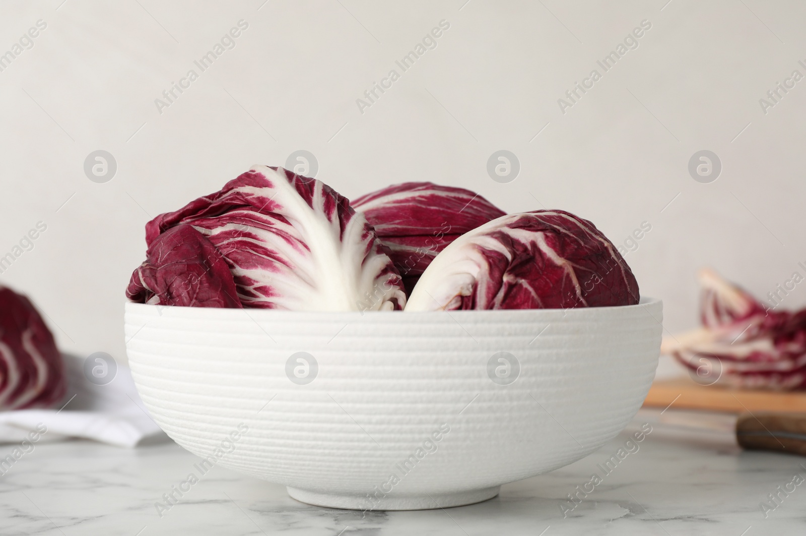 Photo of Whole fresh ripe radicchios on white marble table