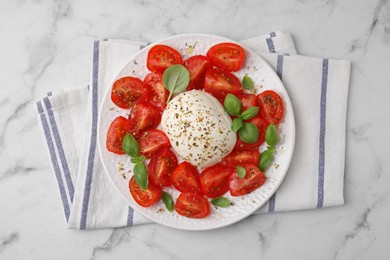 Photo of Tasty salad Caprese with mozarella, tomatoes and basil on white marble table, top view