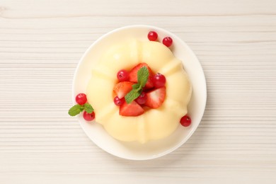 Photo of Delicious semolina pudding with berries on white wooden table, top view