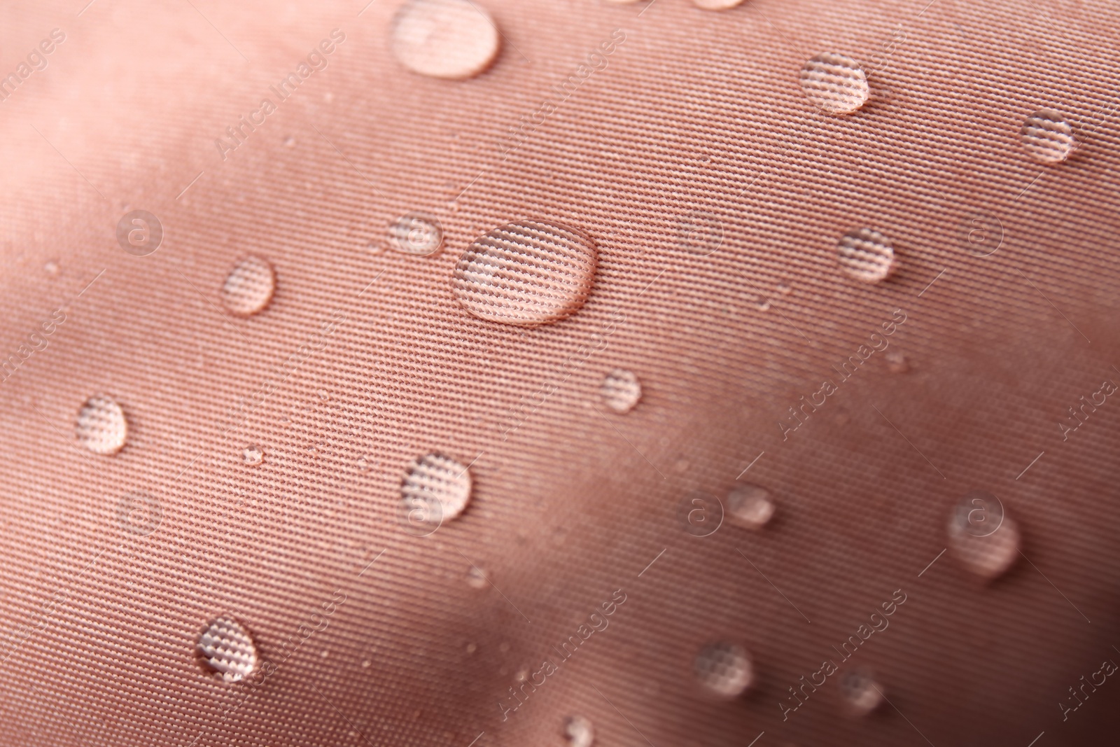 Photo of Pink waterproof fabric with water drops as background, closeup