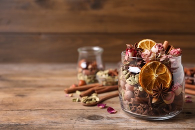 Aroma potpourri with different spices on wooden table, space for text