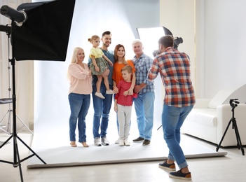 Professional photographer taking photo of family in studio