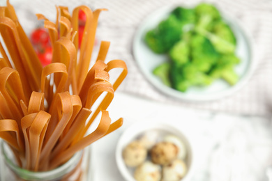 Photo of Uncooked buckwheat noodles on table, closeup. Space for text