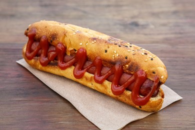 Fresh tasty hot dog with ketchup on wooden table, closeup