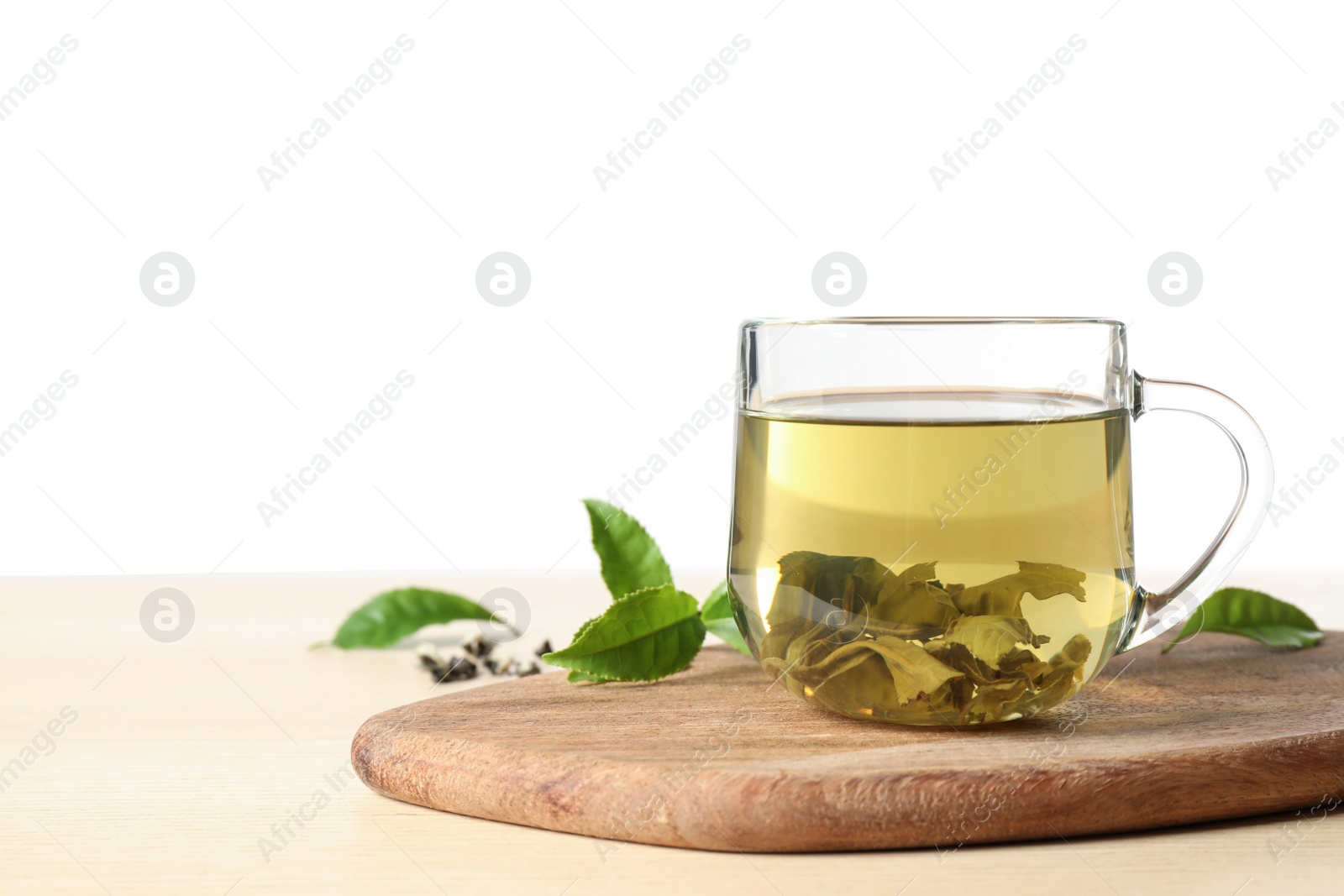 Photo of Tasty hot green tea on wooden table against white background