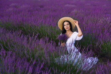 Photo of Beautiful young woman sitting in lavender field