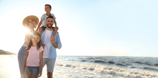 Image of Happy family on beach near sea, space for text. Banner design
