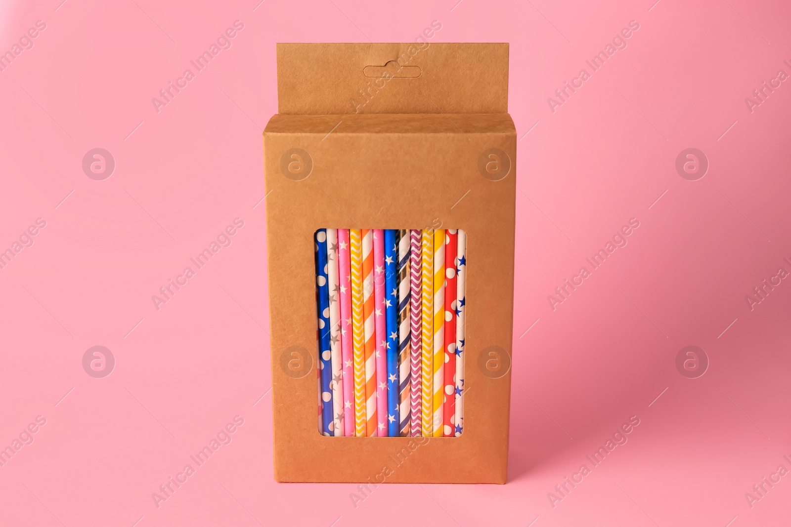 Photo of Box with many paper drinking straws on pink background