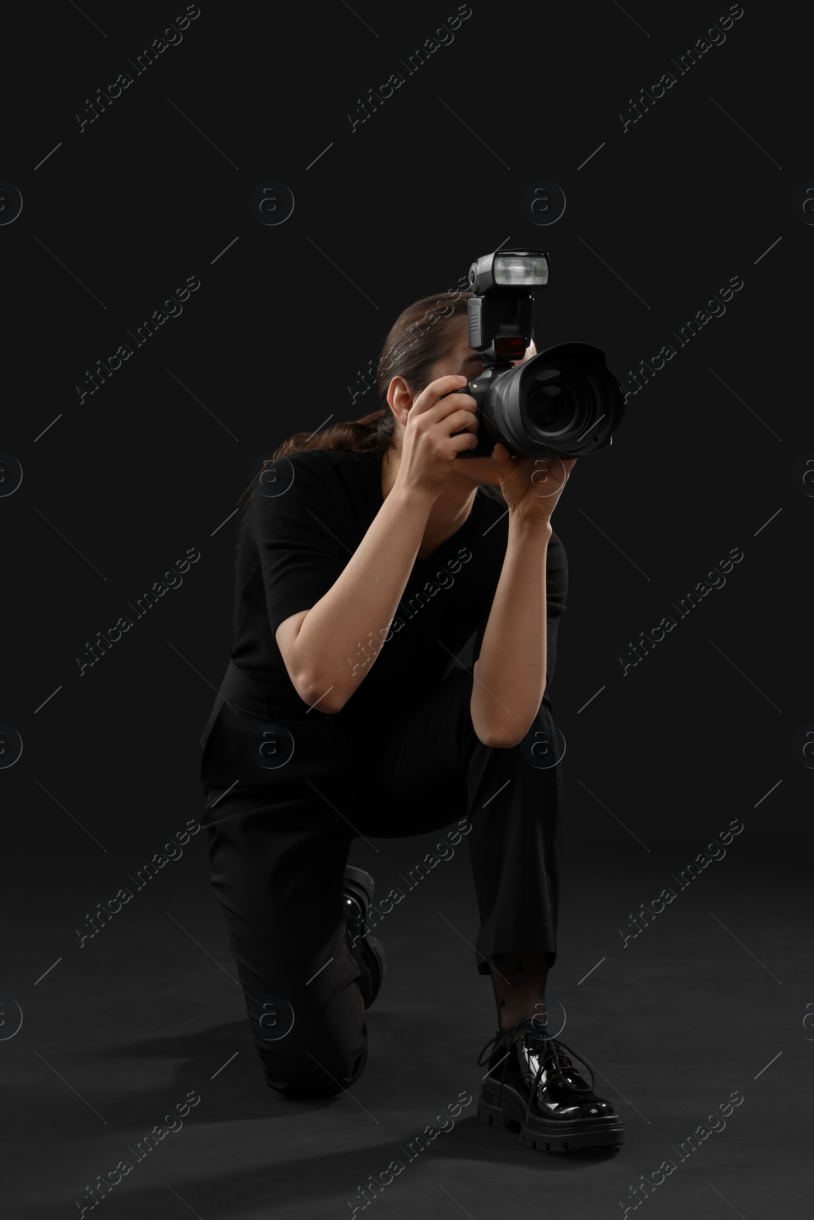 Photo of Professional photographer taking picture on black background