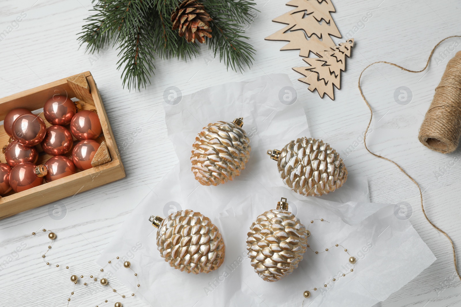 Photo of Flat lay composition with beautiful Christmas baubles on white wooden table