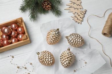 Flat lay composition with beautiful Christmas baubles on white wooden table