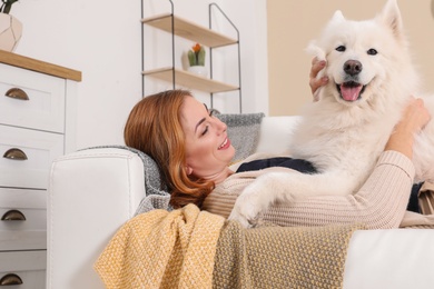 Photo of Beautiful woman with her dog lying on sofa at home