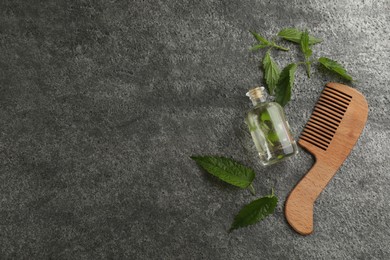 Photo of Stinging nettle, extract and comb on grey background, flat lay with space for text. Natural hair care