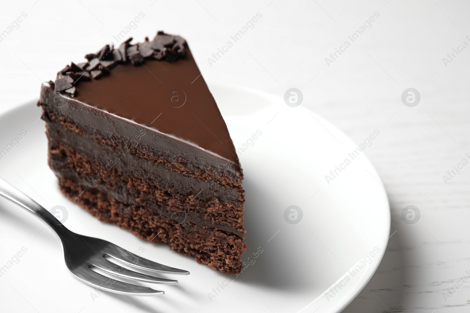 Photo of Delicious fresh chocolate cake served on white table, closeup