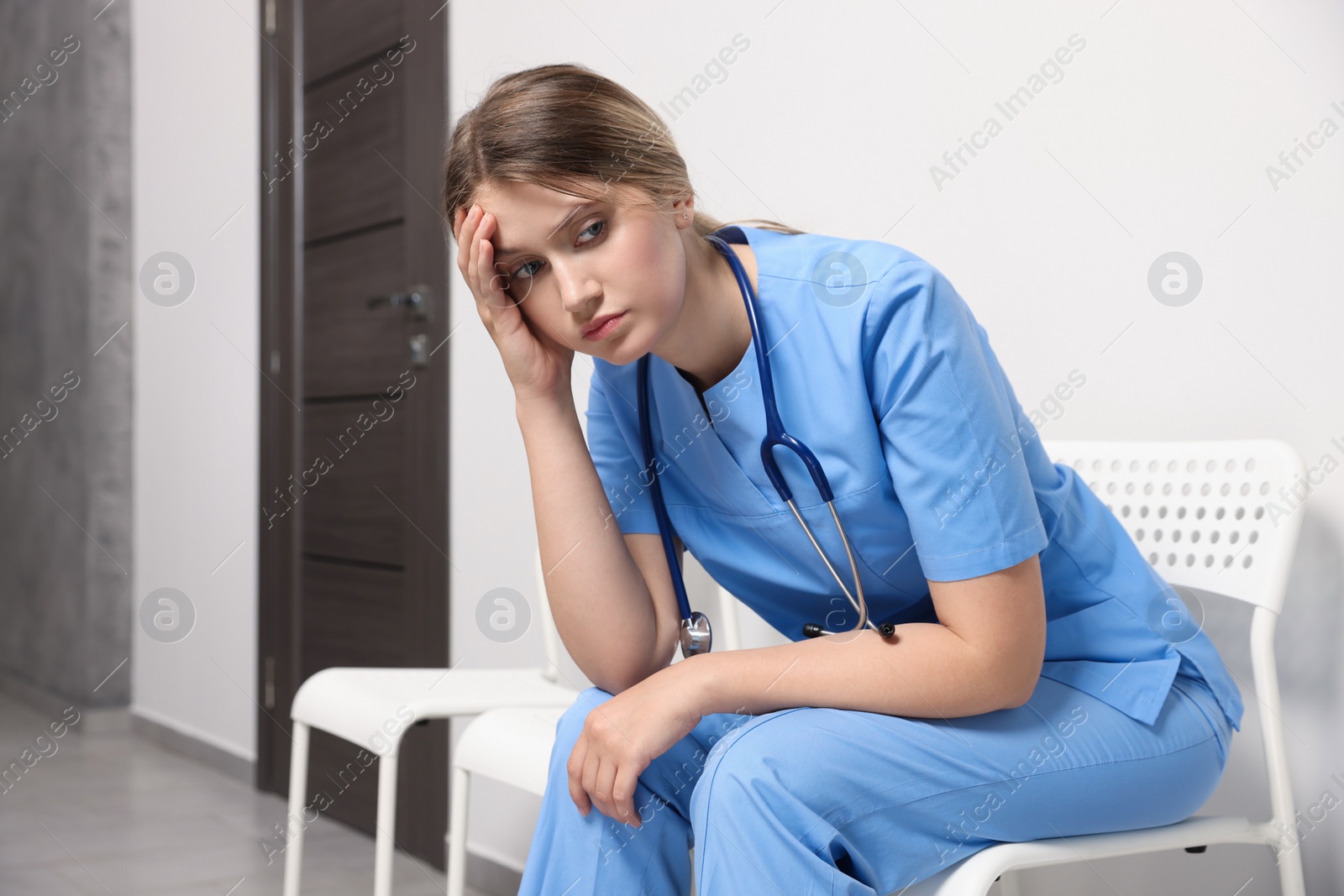 Photo of Exhausted doctor resting on chair in hospital