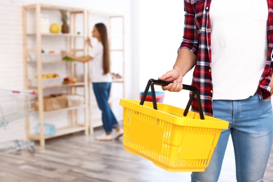 Photo of Man with empty shopping basket in grocery store, closeup