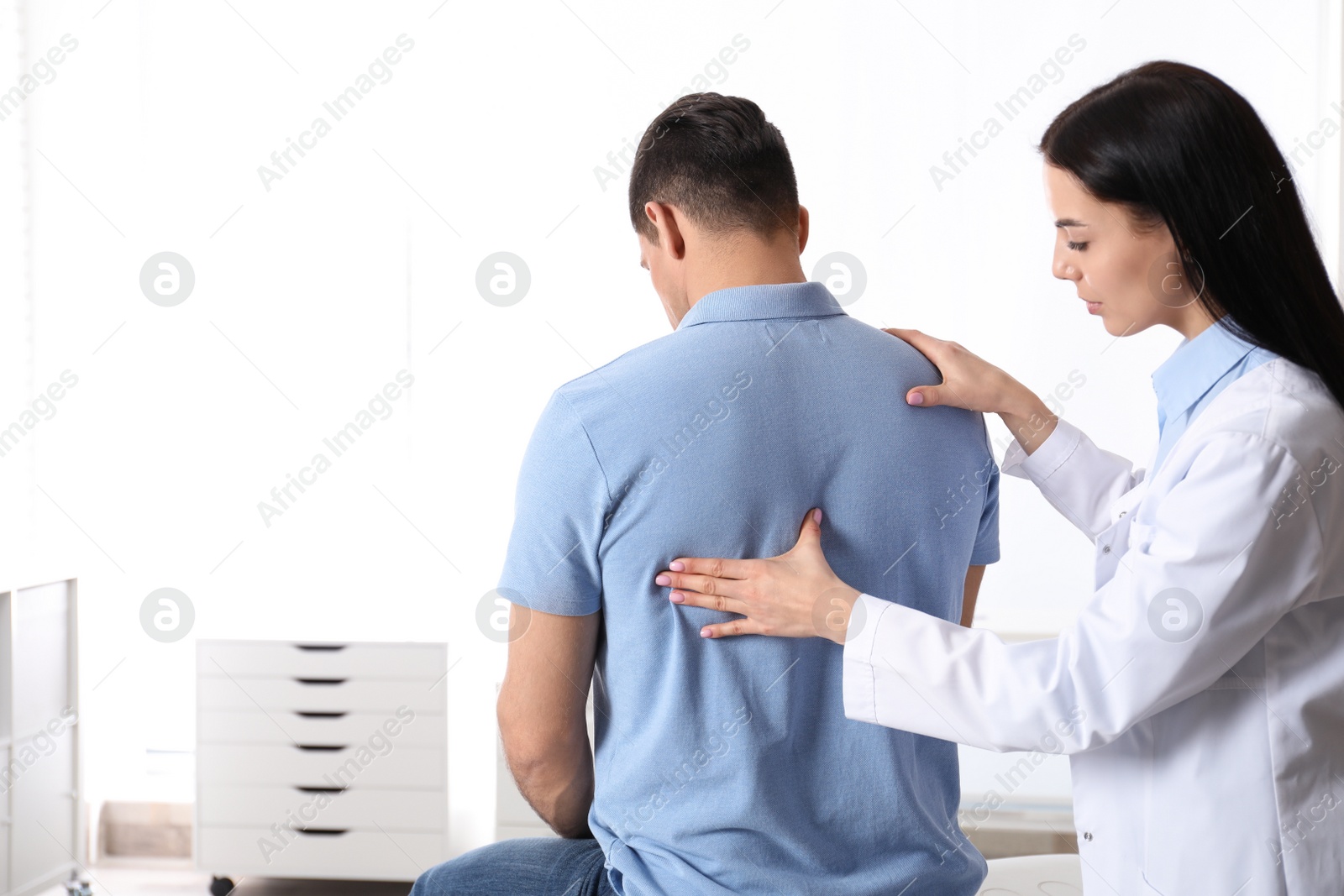 Photo of Professional orthopedist examining man in medical office