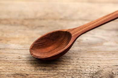 Photo of Clean new spoon on wooden background, closeup