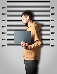 Image of Criminal mugshot. Arrested man with blank card against height chart