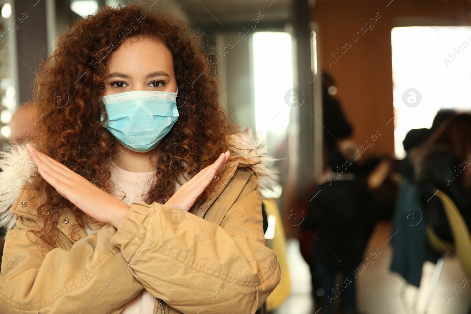 Photo of African-American woman with disposable mask in cafe. Virus protection