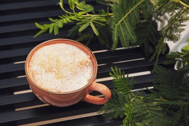 Photo of Ceramic cup of aromatic coffee with foam on wooden table