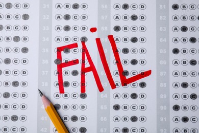 Photo of Word Fail written with red marker on answer sheet, flat lay. Student passing exam