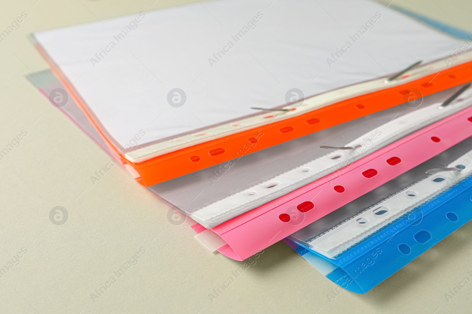 Photo of File folders with punched pockets on light grey background, closeup