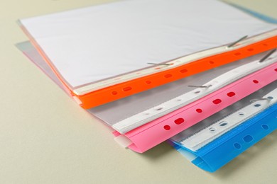 Photo of File folders with punched pockets on light grey background, closeup