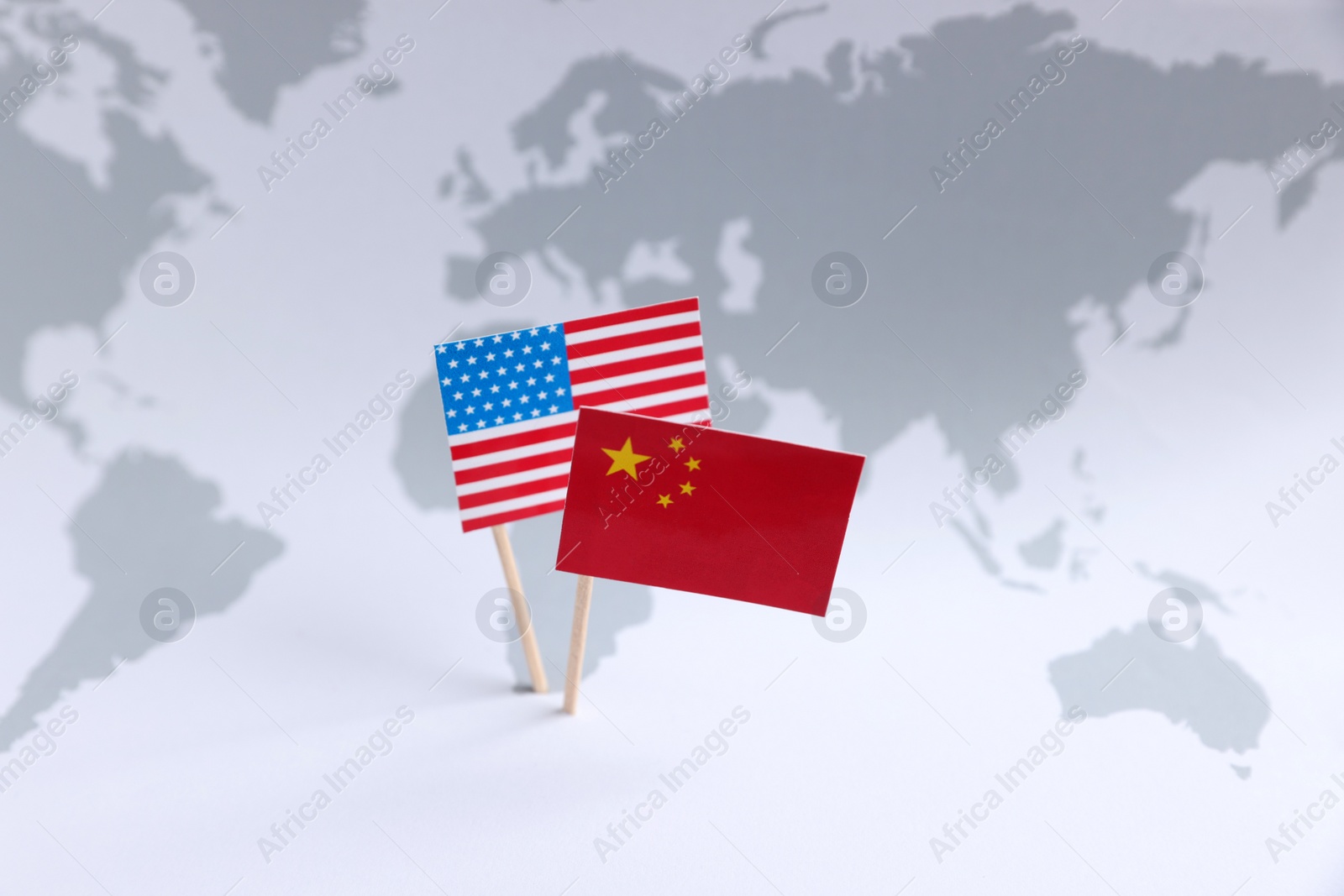 Photo of American and Chinese flags on world map. Trade war concept