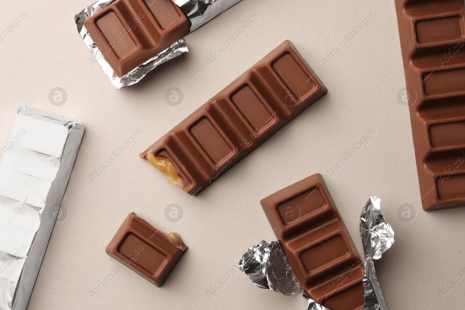 Photo of Tasty chocolate bars on light background, flat lay