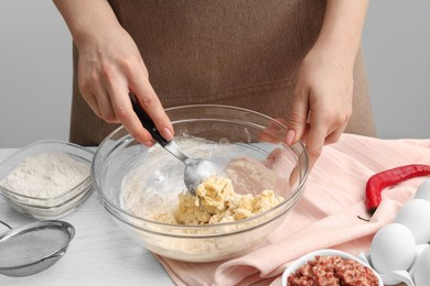 Photo of Woman making dough at white wooden table, closeup