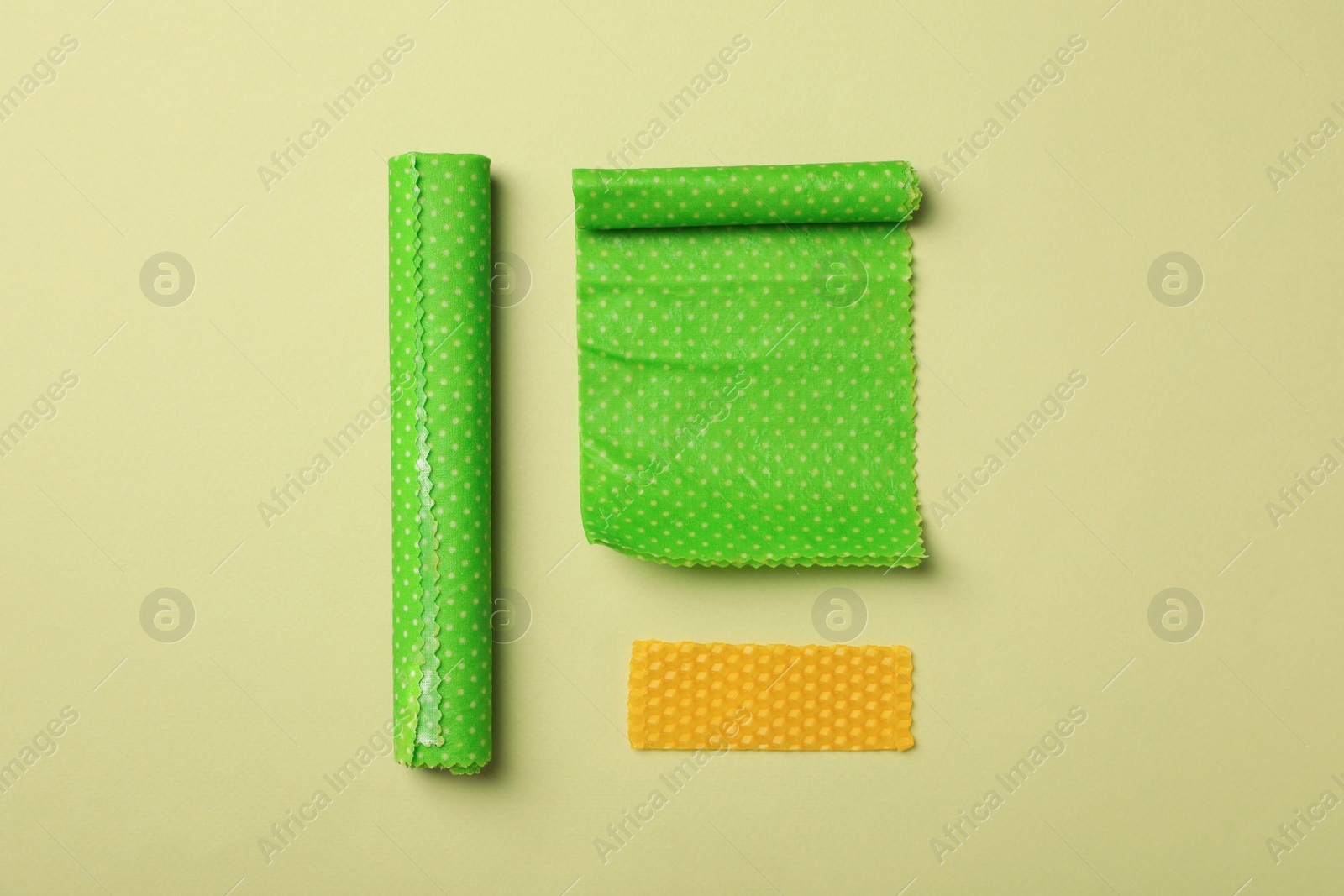 Photo of Beeswax food wraps on light green background, flat lay